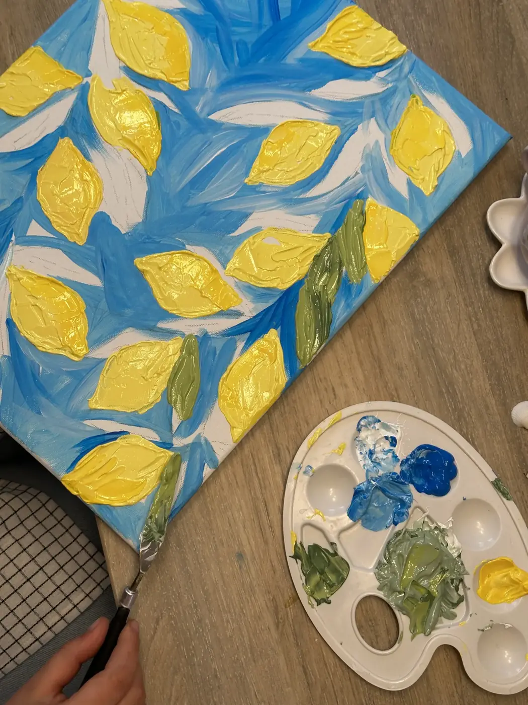 Kleurrijk schilderij met citroenen naast een palet