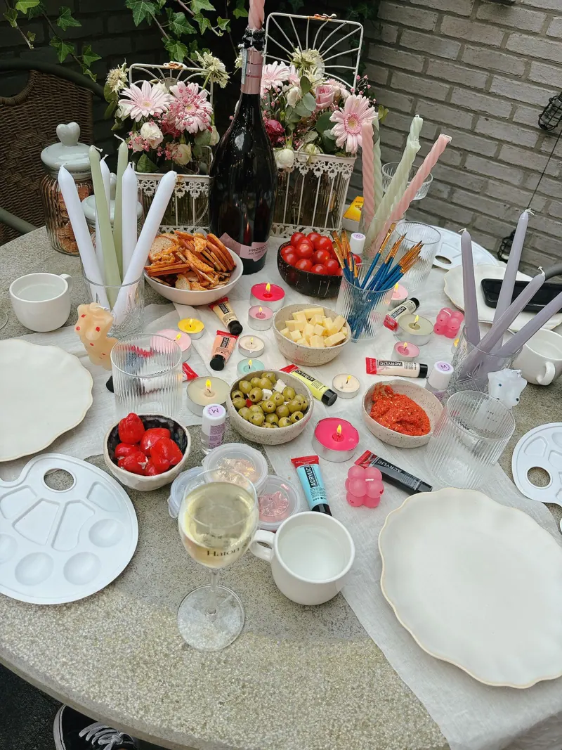 Feesttafel met beschilderde kaarsen, fruit en verf